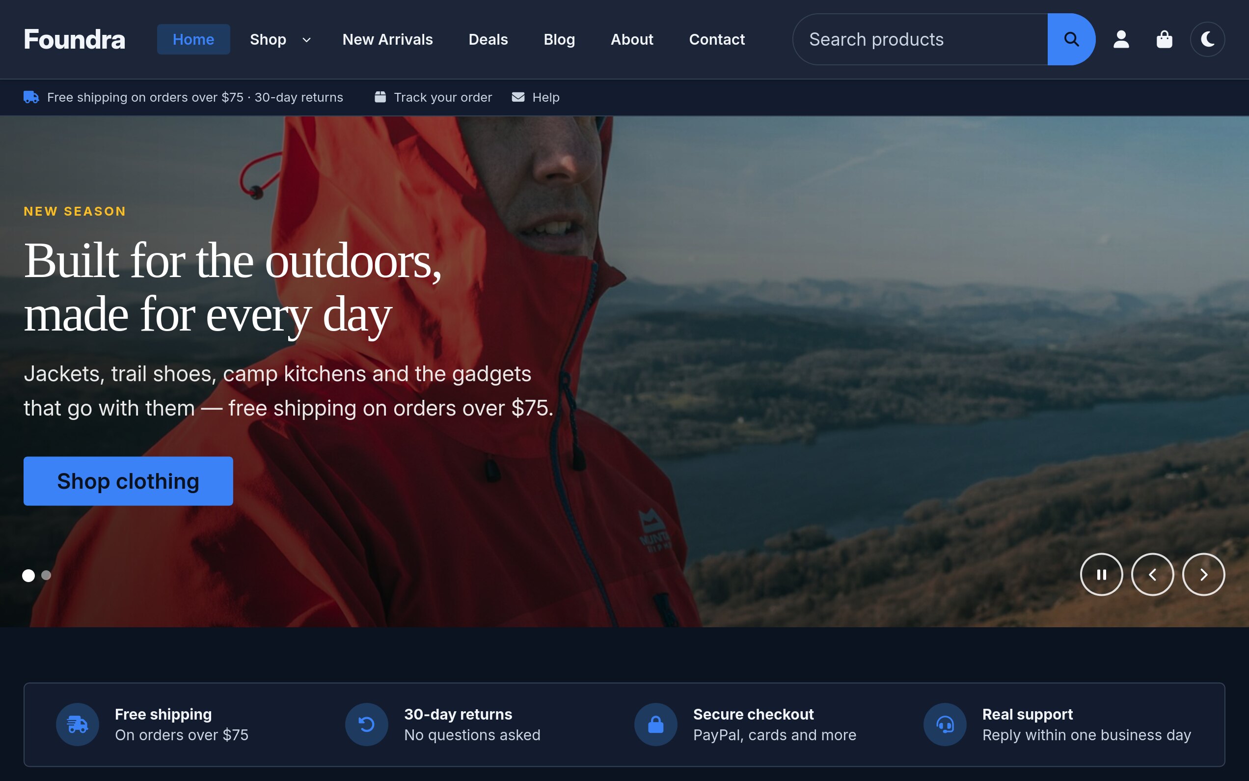 The same Foundra storefront home page in the boutique preset with dark mode on: a deep navy header and utility bar, a serif display headline reading Built for the outdoors, made for every day over the hero photo of a hiker in a red shell jacket, a pale blue Shop clothing button, a moon icon for the dark-mode switcher, and the trust row on dark navy cards