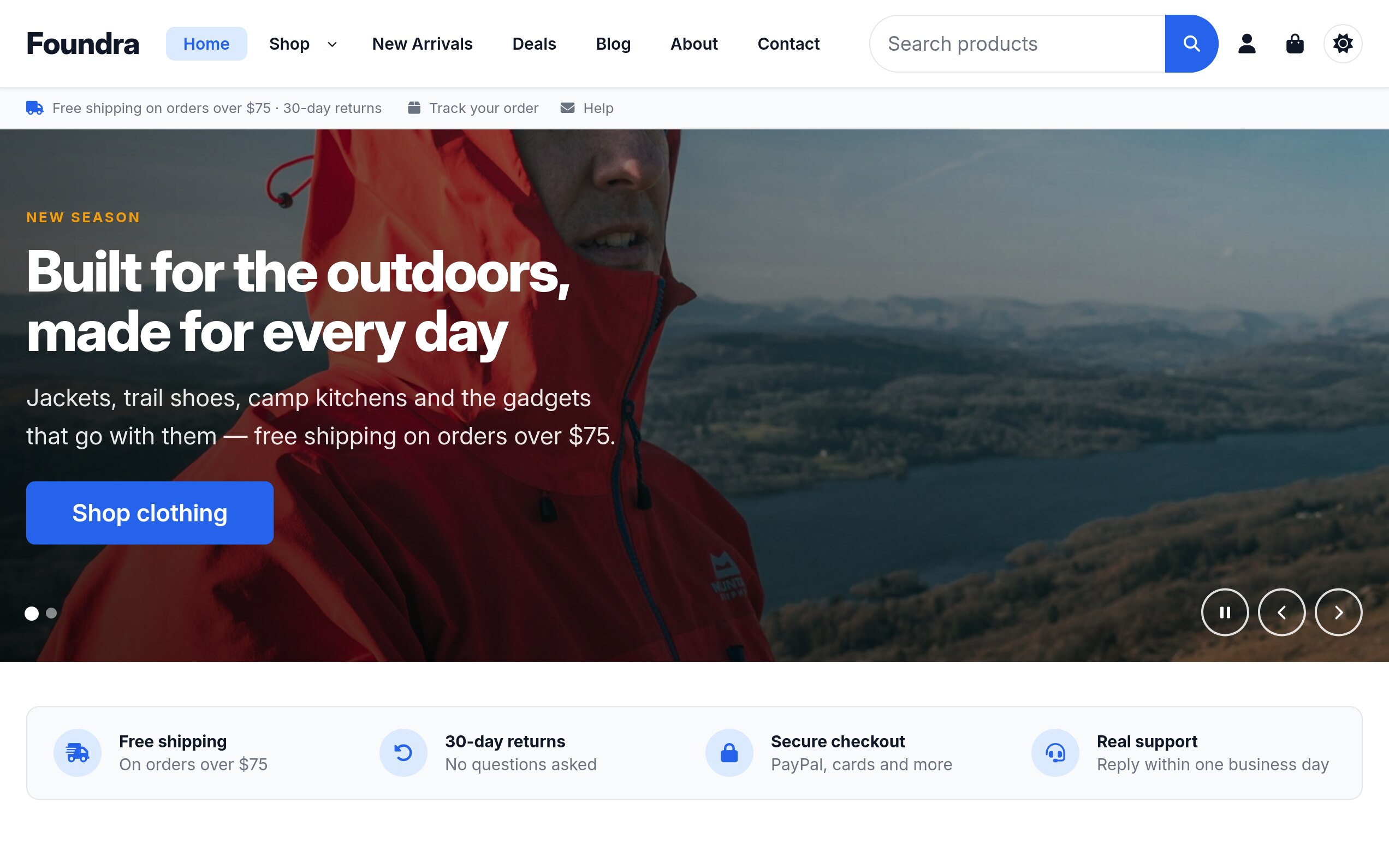 The Foundra storefront home page: a header with the Foundra wordmark, Home, Shop, New Arrivals, Deals, Blog, About and Contact links and a product search field, a utility bar reading free shipping on orders over $75 and 30-day returns beside Track your order and Help, a full-bleed hero of a hiker in a red shell jacket above a lake headlined Built for the outdoors, made for every day with a Shop clothing button, and a trust row listing free shipping, 30-day returns, secure checkout and real support